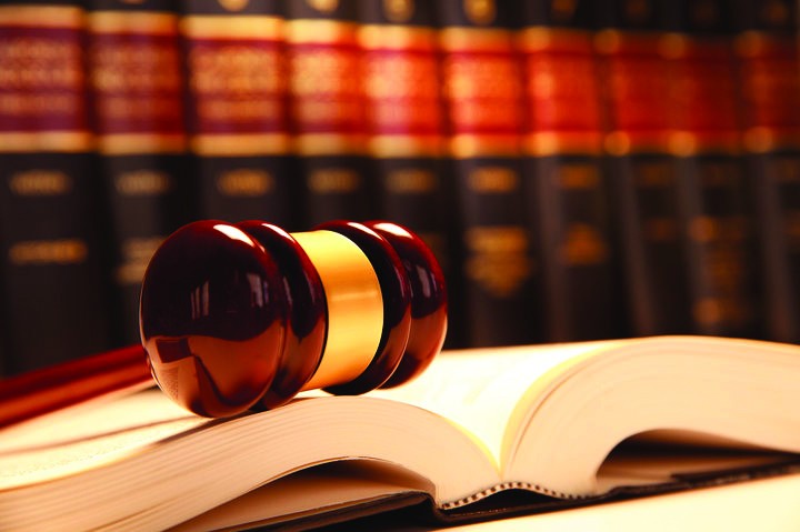 Photo of a row of law books behind an open book and gavel
